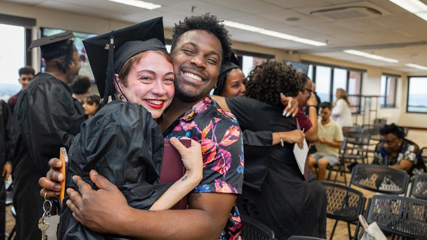 HiSET Graduate hugging significant other